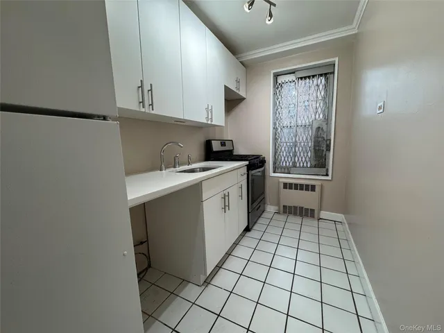 a kitchen with a sink a stove cabinets and utility room