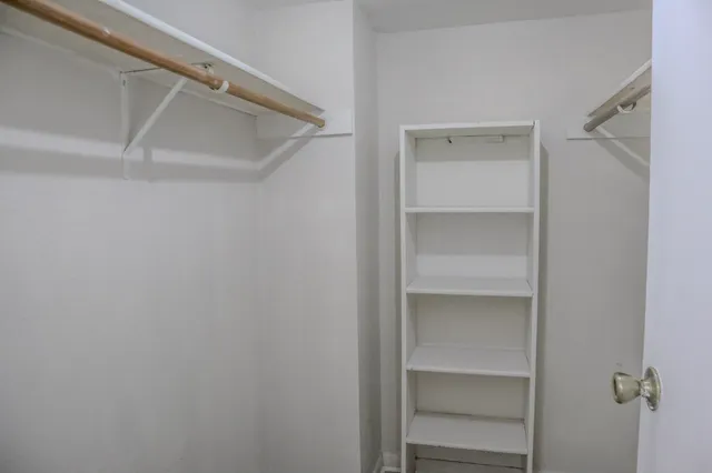 a view of walk in closet with empty racks