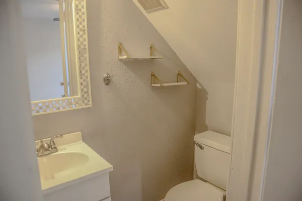 a bathroom with a toilet sink and mirror