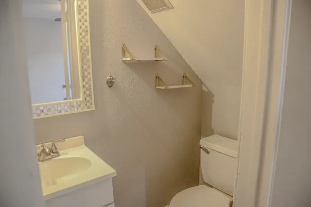 a bathroom with a toilet sink and mirror