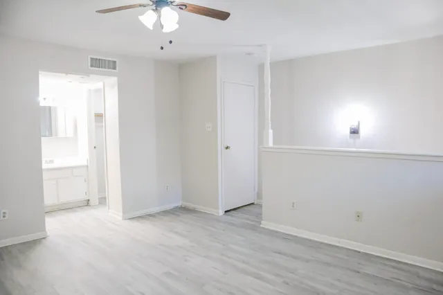 an empty room with chandelier fan