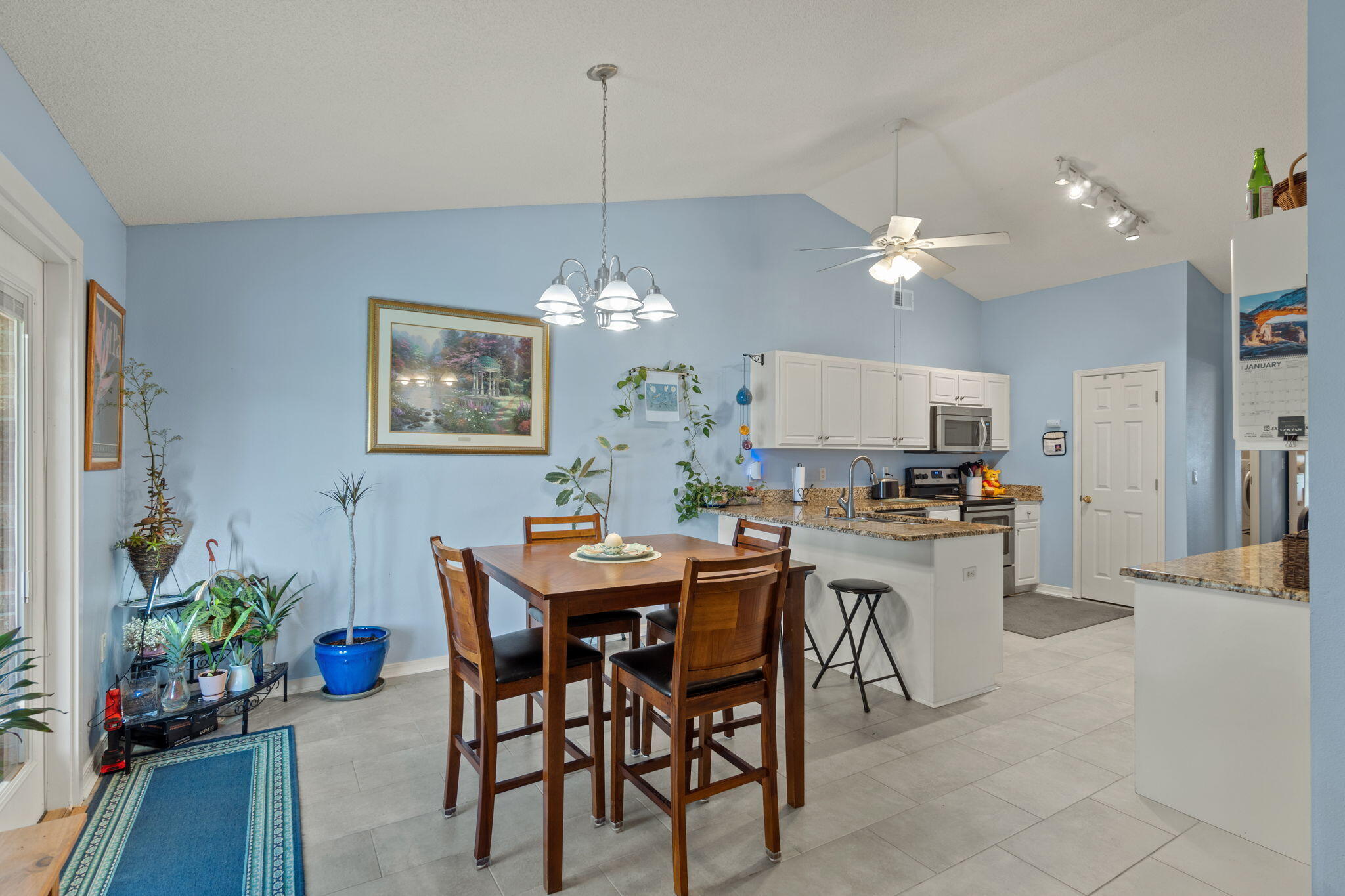 2121 Ortega Street Navarre, FL 32566 - Photo 11 of 47 a view of a dining room with furniture a chandelier and wooden floor