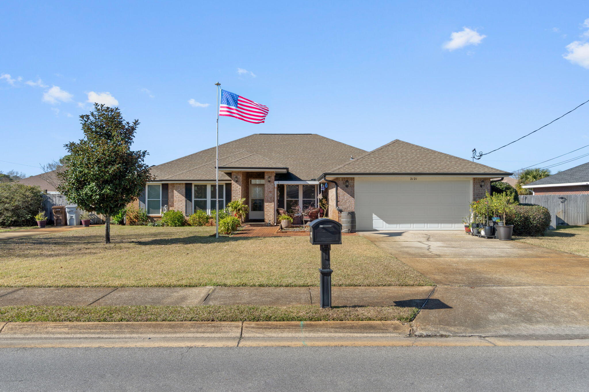 2121 Ortega Street Navarre, FL 32566 - Photo 2 of 47 a front view of a house with garden
