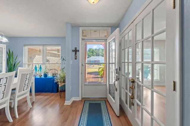 a view of a hallway with furniture and wooden floor