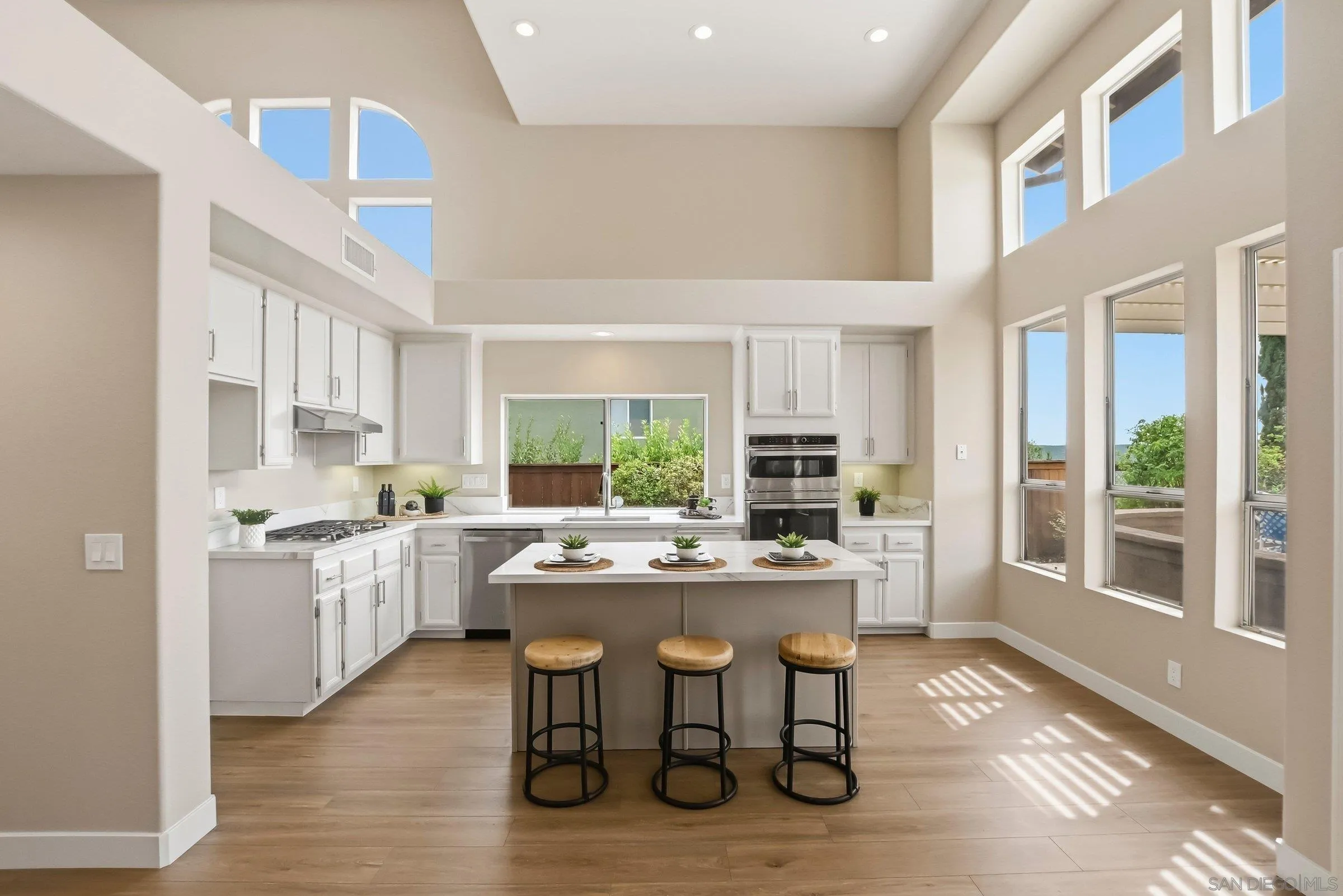 12182 Mannix Road San Diego, CA 92129 - Photo 14 of 43 a kitchen with a table chairs stove and cabinets