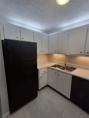 a kitchen with a refrigerator and a sink