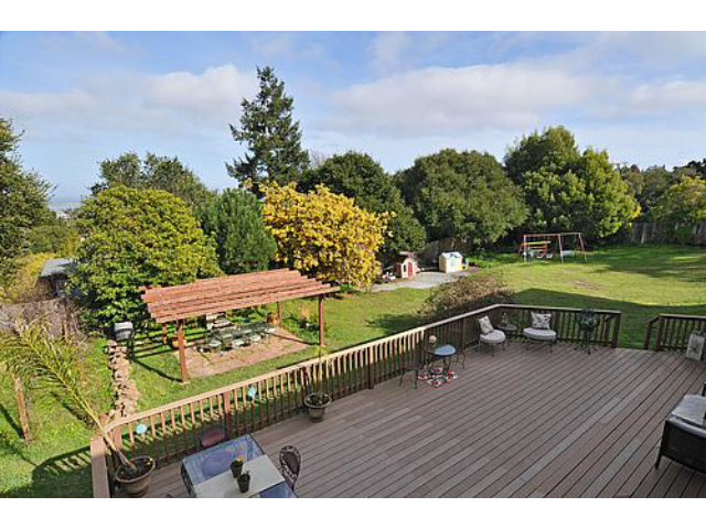 a view of a wooden deck with a yard