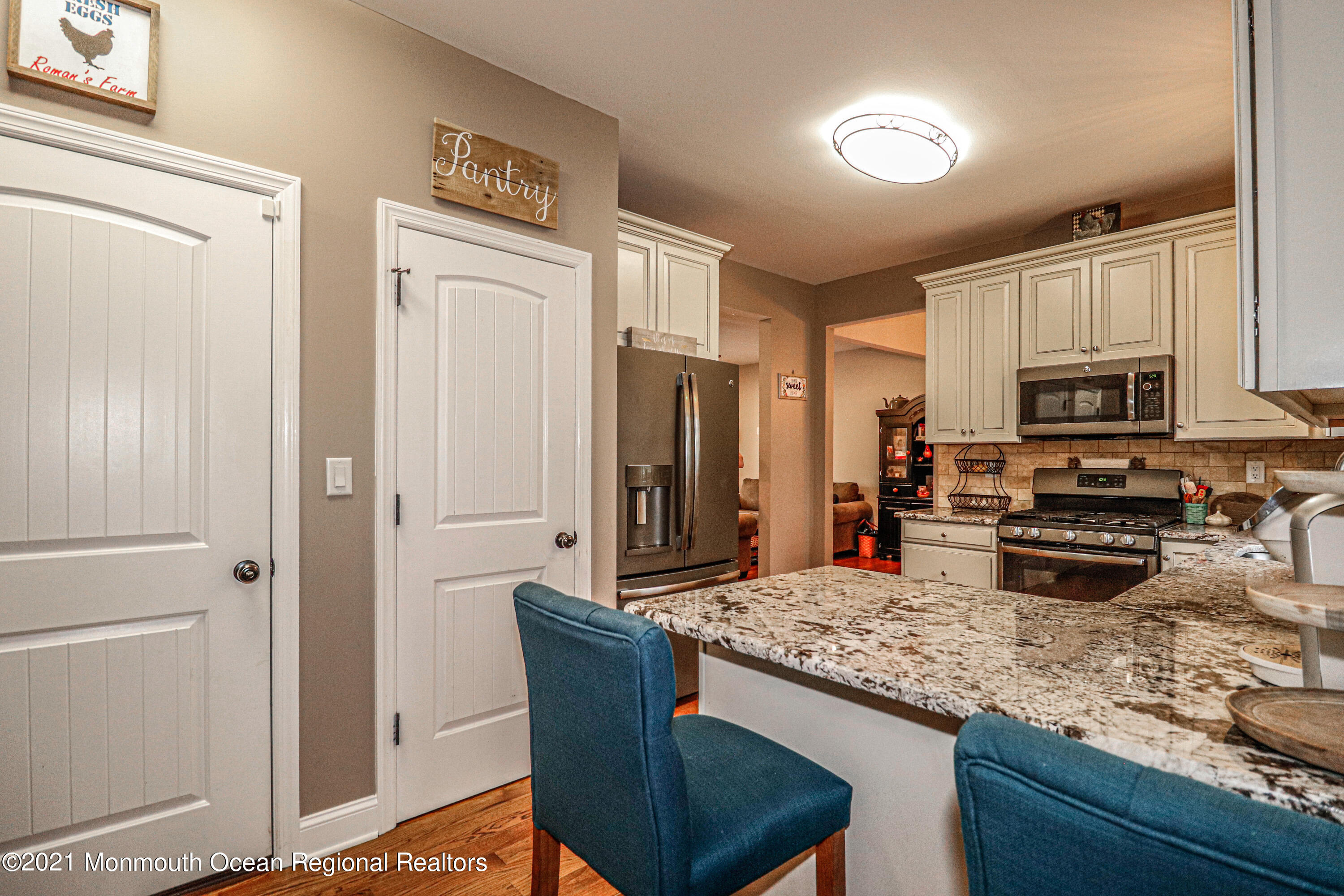 10 Letts Landing Road Waretown, NJ 08758 - Photo 15 of 51 a kitchen with stainless steel appliances granite countertop a stove top oven a sink dishwasher a dining table and chairs with wooden floor