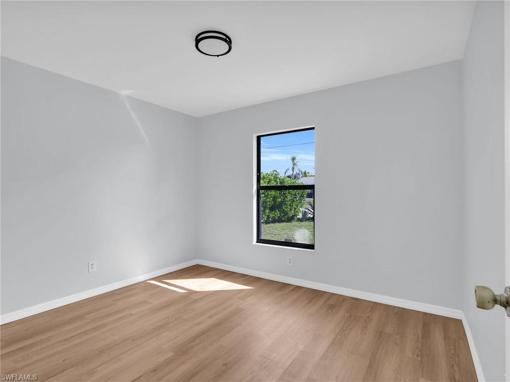 4991 18th Court Southwest Naples, FL 34116 - Photo 18 of 36 an empty room with wooden floor and windows