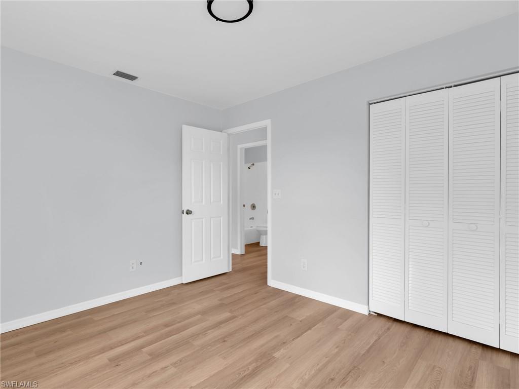4991 18th Court Southwest Naples, FL 34116 - Photo 19 of 36 a view of an empty room with wooden floor