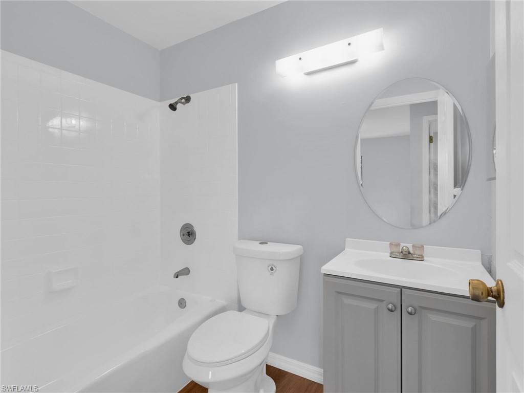 4991 18th Court Southwest Naples, FL 34116 - Photo 20 of 36 a bathroom with a toilet a sink a mirror and vanity