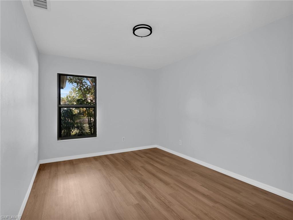 4991 18th Court Southwest Naples, FL 34116 - Photo 21 of 36 a view of an empty room with wooden floor and a window