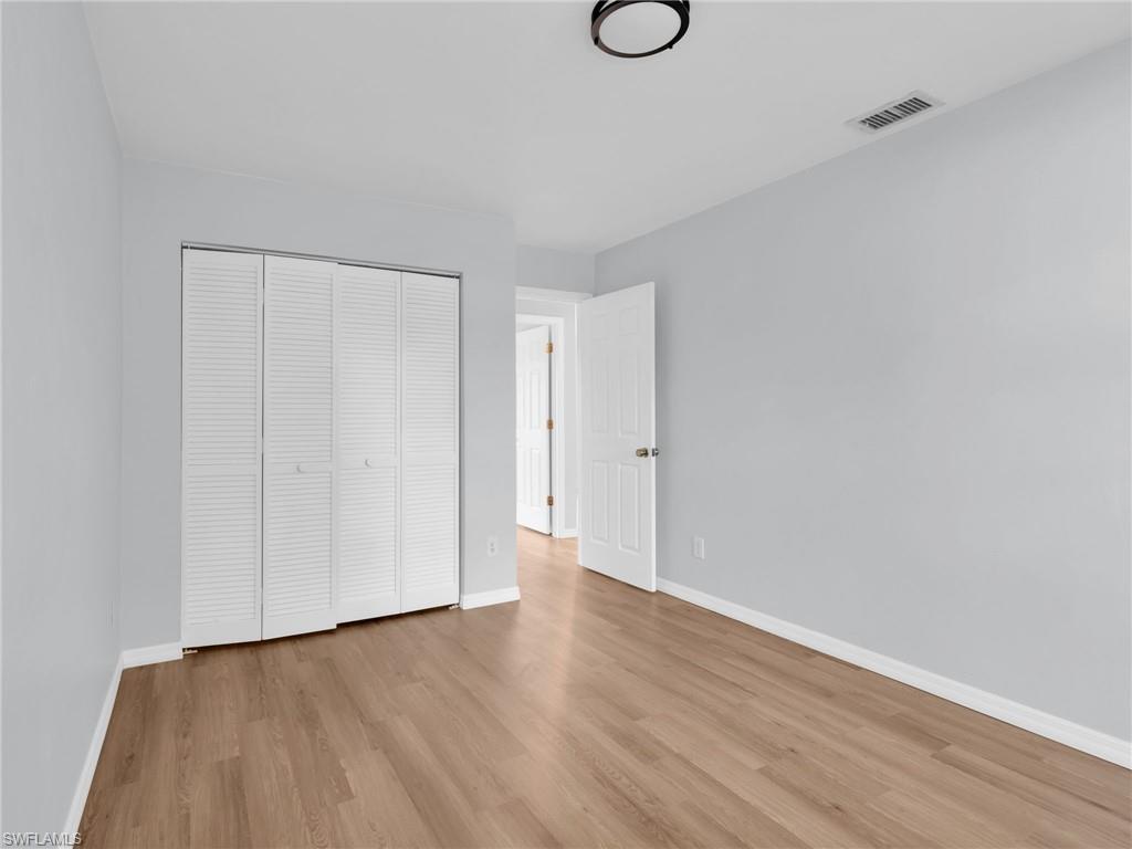 4991 18th Court Southwest Naples, FL 34116 - Photo 22 of 36 a view of an empty room with wooden floor and a window