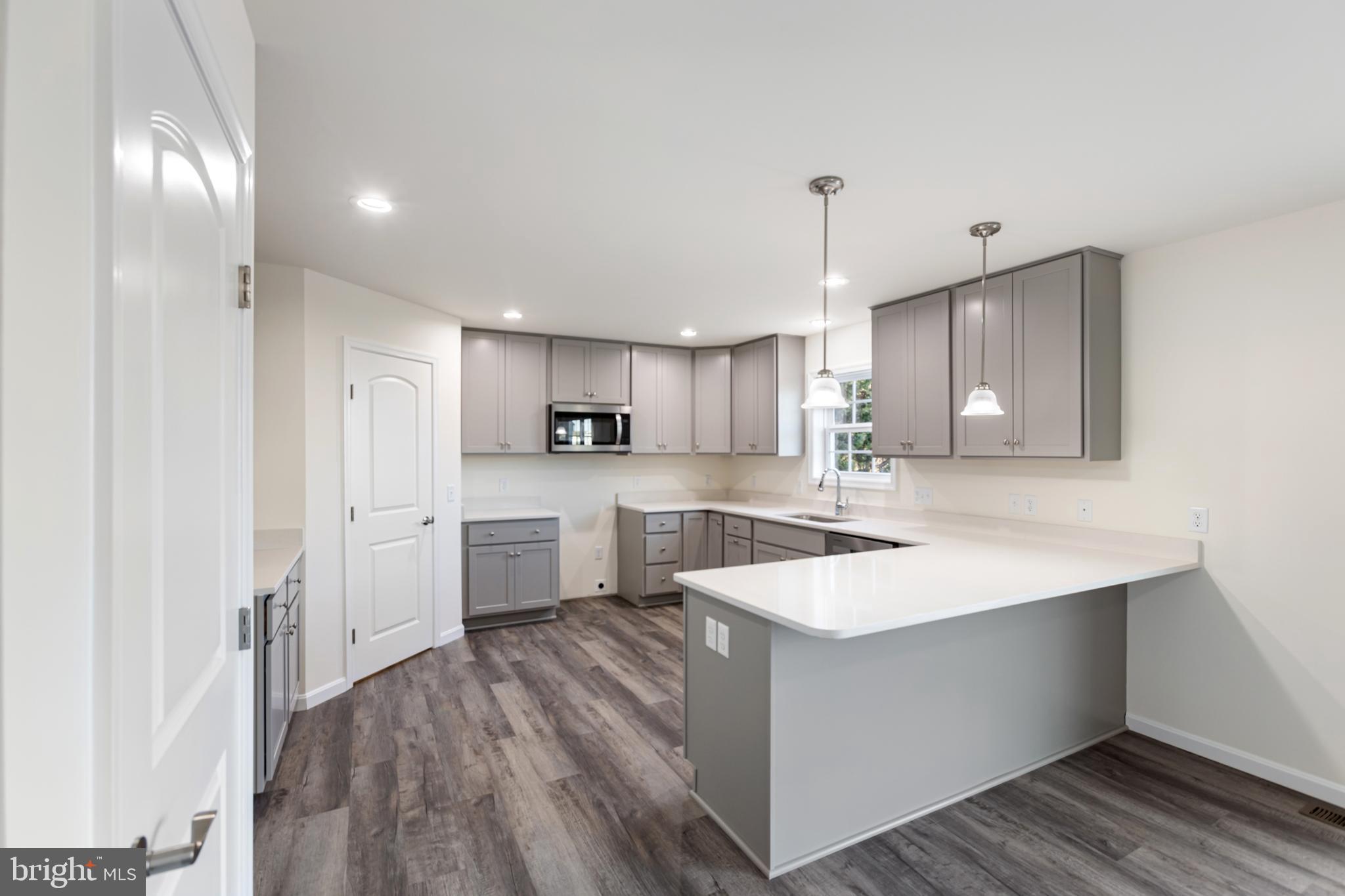 21625 Hackney Circle Lincoln, DE 19960 - Photo 22 of 46 a large white kitchen with wooden floor
