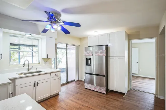 a kitchen with stainless steel appliances a refrigerator a sink dishwasher a oven with wooden floor