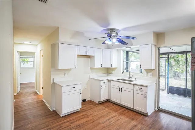 a kitchen with a white cabinets and chandelier