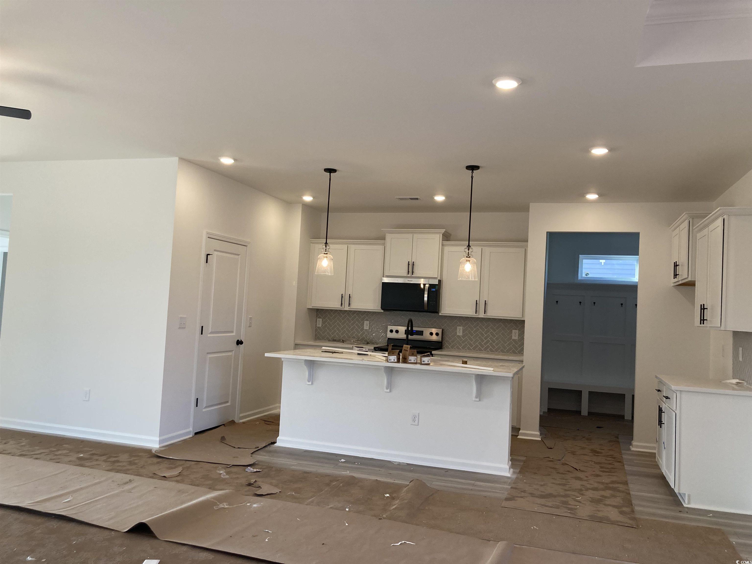 137 River Birch Drive Loris, SC 29569 - Photo 3 of 17 Kitchen featuring a breakfast bar area, tasteful backsplash, hanging light fixtures, white cabinets, and appliances with stainless steel finishes