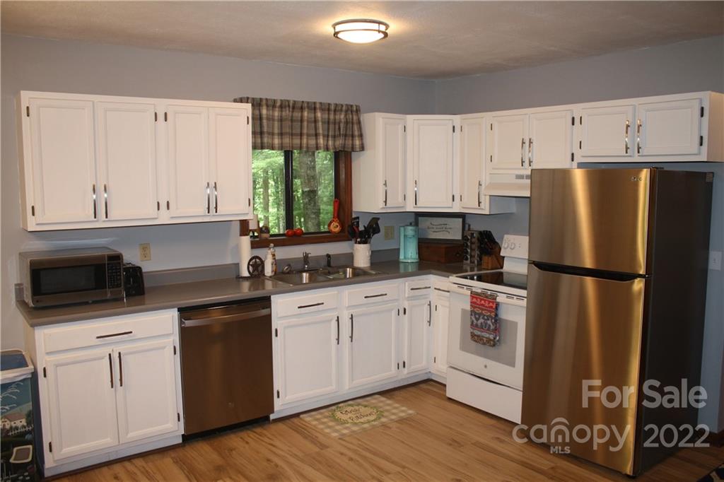 33 Fernbrook Road Maggie Valley, NC 28751 - Photo 6 of 36 a kitchen with granite countertop white cabinets and white appliances