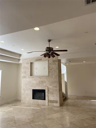 a living room with a fireplace and a ceiling fan
