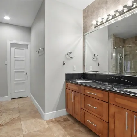 a bathroom with a granite countertop sink and a mirror