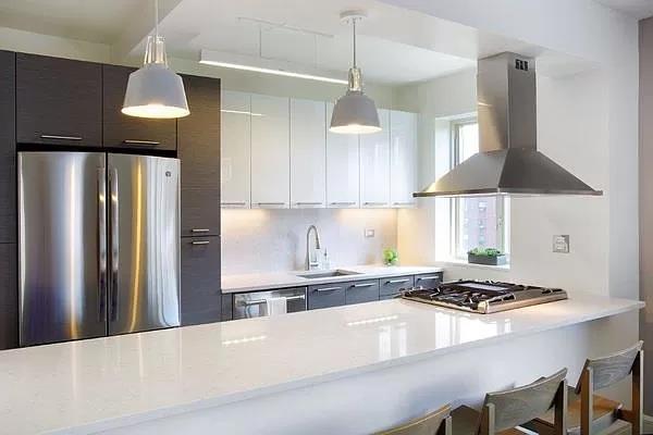 a kitchen with stainless steel appliances chandelier a refrigerator and a stove