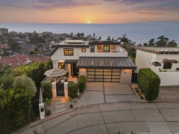 an aerial view of a house with a yard fire pit and outdoor seating