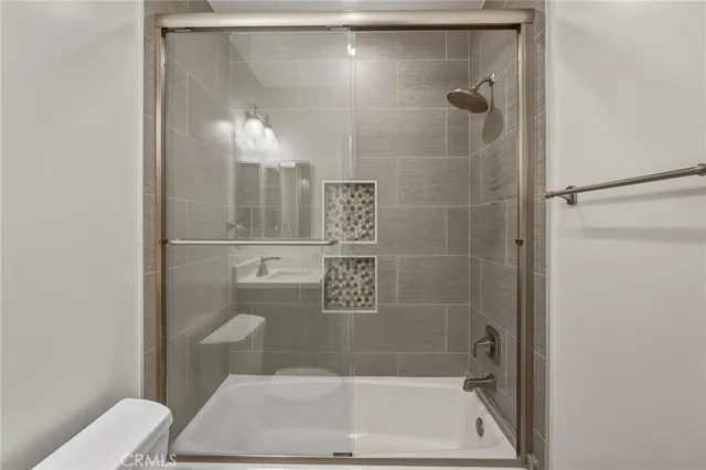 a bathroom with a shower a toilet and a sink