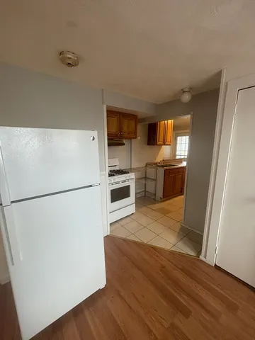 a white refrigerator freezer and a stove sitting inside of a kitchen