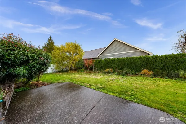 a backyard of a house with plants and wooden fence