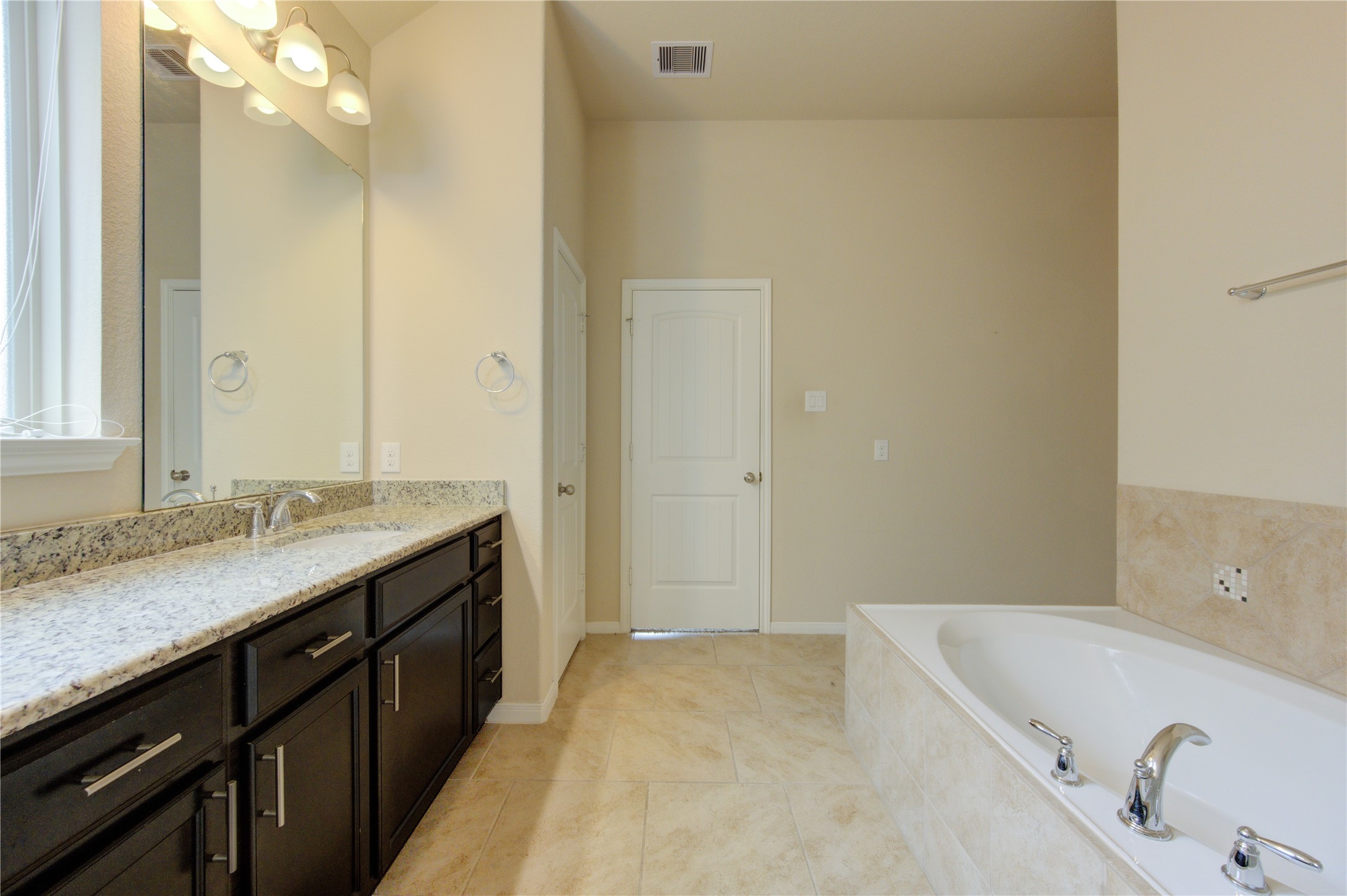 18106 Dorman Draw Lane Houston, TX 77044 - Photo 20 of 27 a bathroom with a tub sink and mirror