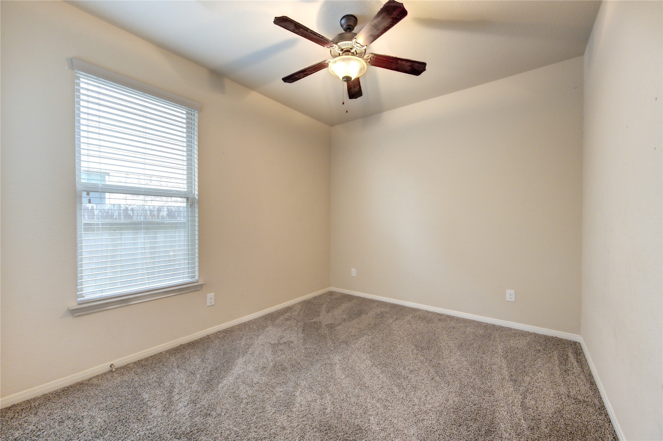 18106 Dorman Draw Lane Houston, TX 77044 - Photo 22 of 27 an empty room with a window and a fan