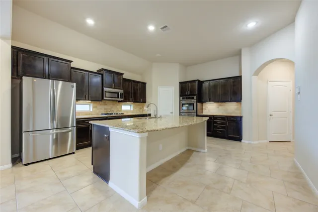 a large kitchen with stainless steel appliances and a refrigerator