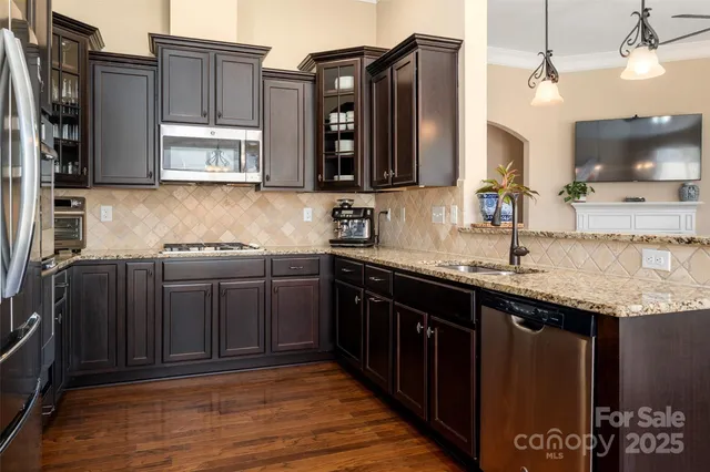 a kitchen with stainless steel appliances granite countertop a sink stove and cabinets