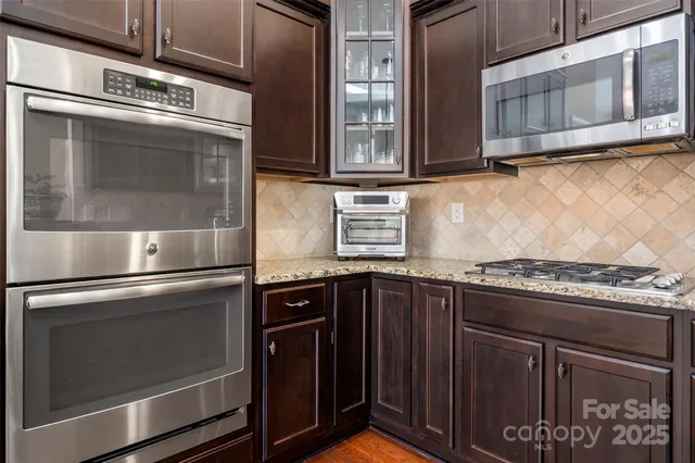 a kitchen with stainless steel appliances granite countertop a stove and a microwave