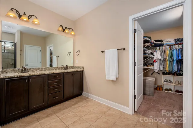 a spacious bathroom with a double vanity sink a mirror and shower