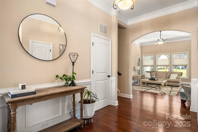 a view of a livingroom with furniture wooden floor and a mirror