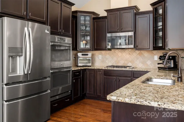 a kitchen with stainless steel appliances granite countertop a refrigerator stove and microwave