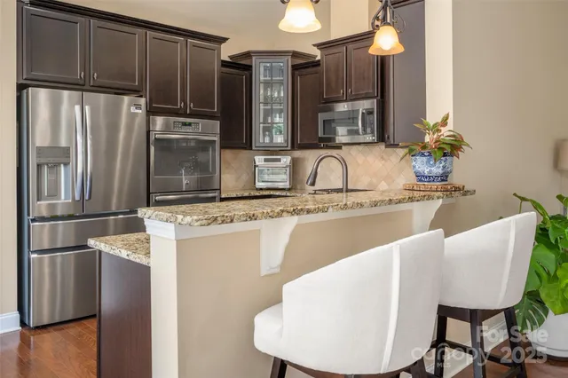a kitchen with kitchen island a appliances a sink and a refrigerator