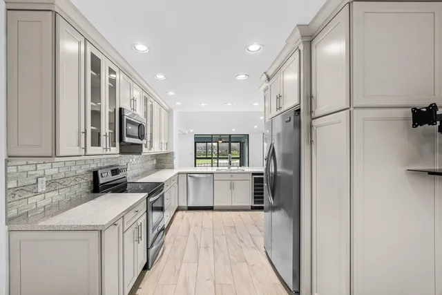 a kitchen with a sink refrigerator and cabinets