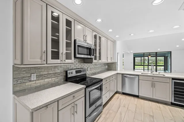 a kitchen with stainless steel appliances granite countertop a sink and stove top oven