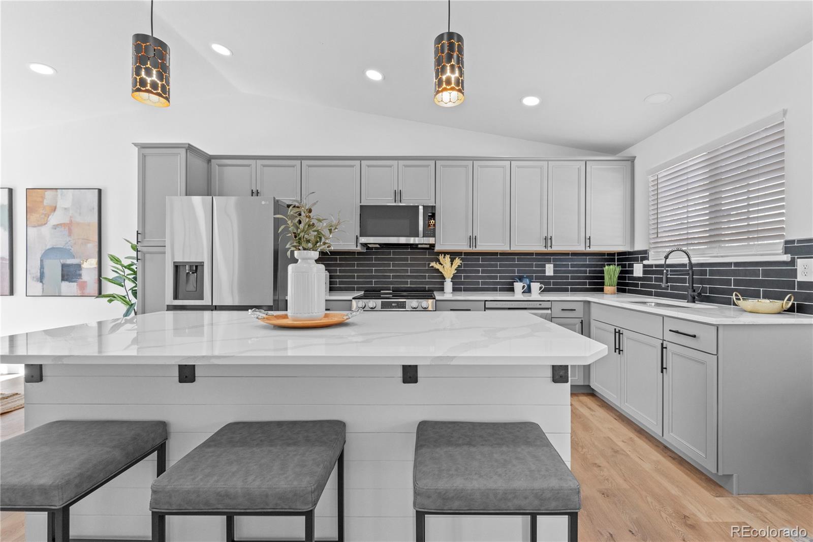 4865 Apollo Bay Drive Highlands Ranch, CO 80130 - Photo 12 of 38 a kitchen with stainless steel appliances granite countertop a table chairs sink refrigerator and microwave