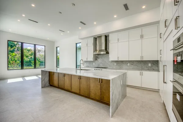 a large white kitchen with a large window