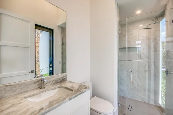 a bathroom with a granite countertop sink toilet and shower