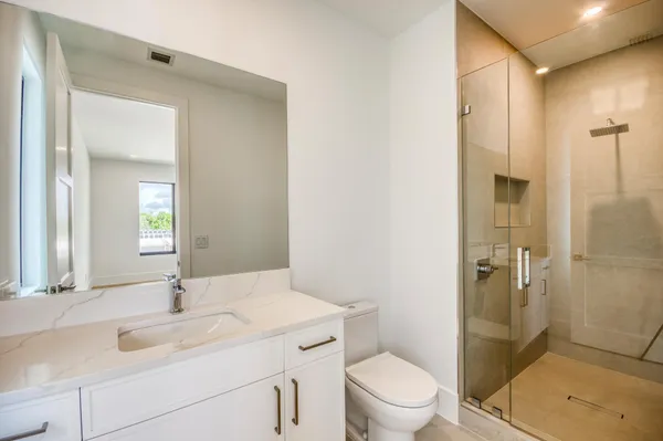 a bathroom with a sink toilet vanity and shower