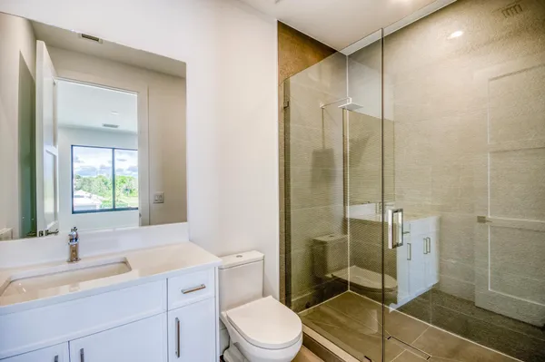 a bathroom with a sink a toilet and shower