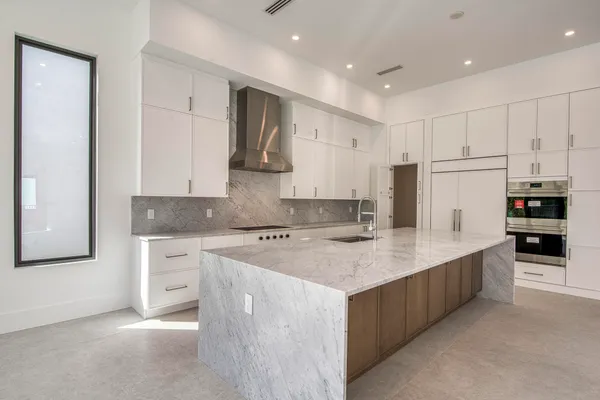 a large kitchen with stainless steel appliances granite countertop a stove a sink and a refrigerator