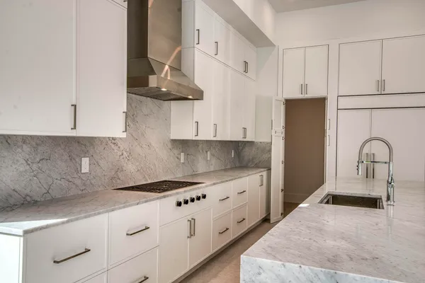 a kitchen with stainless steel appliances granite countertop a sink a stove and a refrigerator