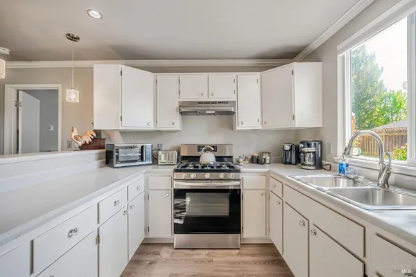 a kitchen with granite countertop a sink stainless steel appliances and cabinets