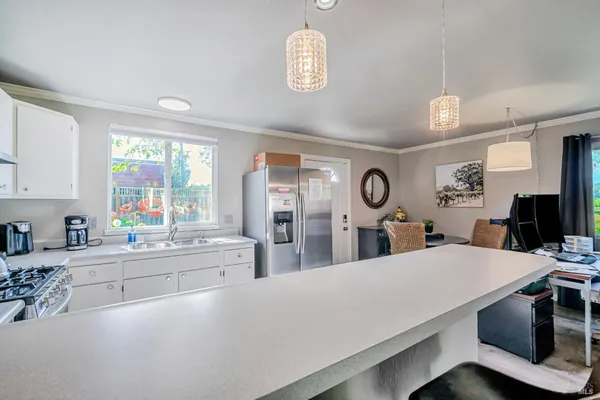 a large white kitchen with a large window