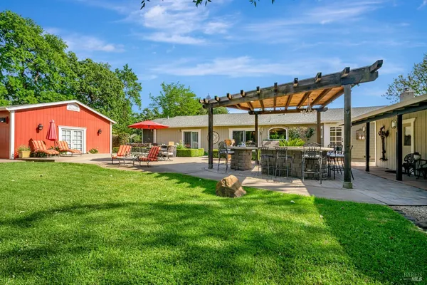 a front view of a house with yard patio and swimming pool